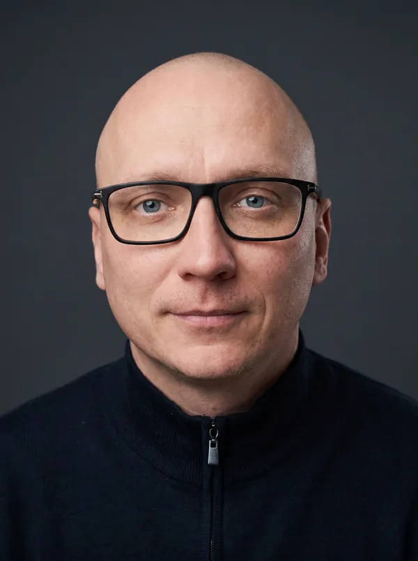 Porträt von André Herrmann vor schiefergrauem Grund